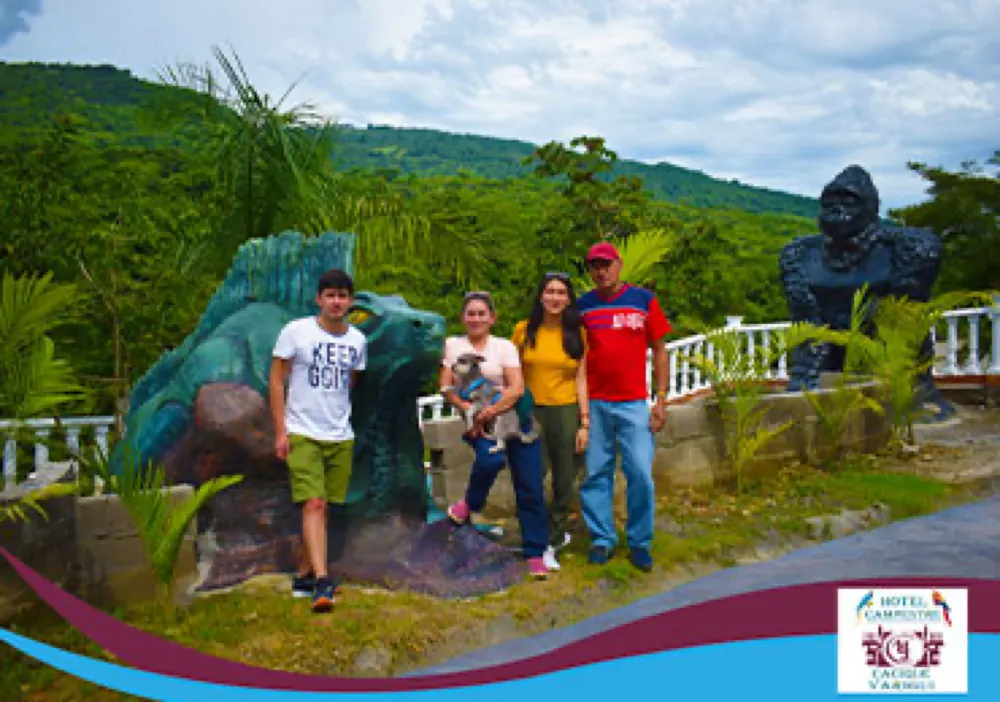Familia junto a las esculturas de dinosaurio y gorila del hotel