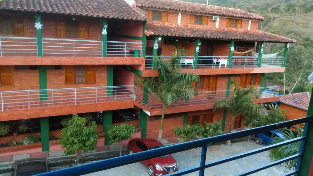 Bloques naranja y verde del hotel con balcones y palmas