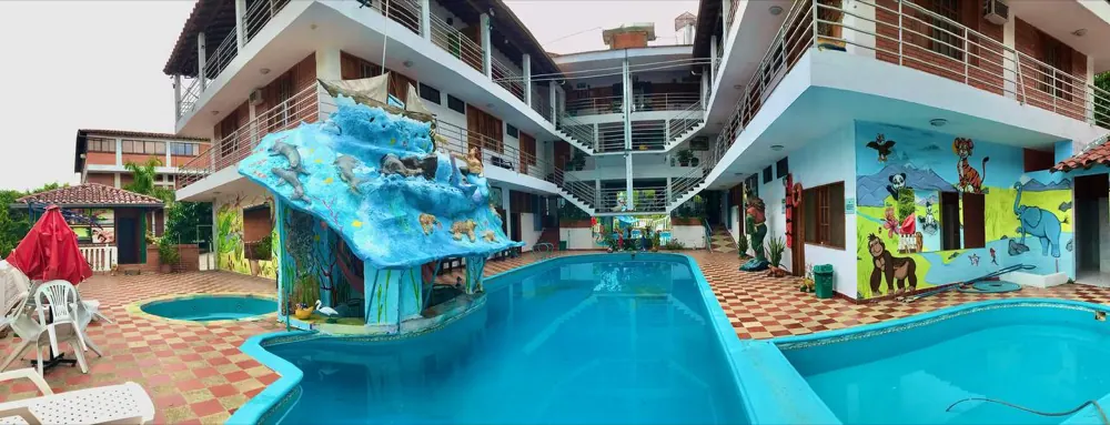 Piscina larga del hotel con murales pintados en las paredes